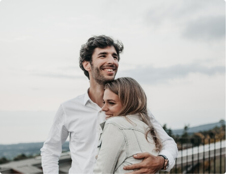 Couple hugging and smiling outdoors