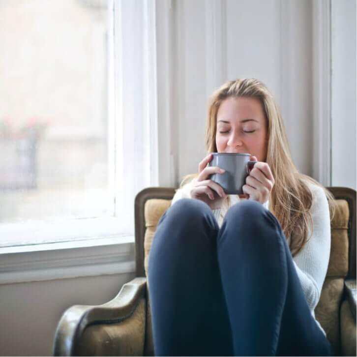 Woman sitting and drinking from a mug