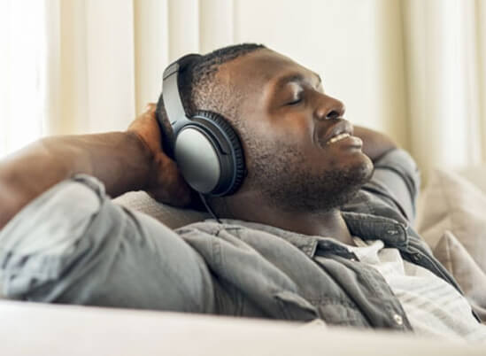Man listening to headphones on a couch