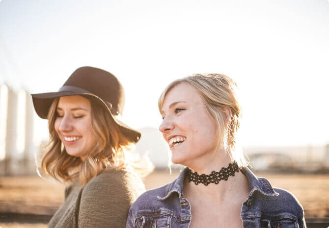 Two young women smiling outside