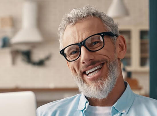 Older man with glasses smiling